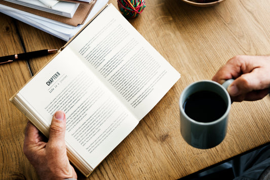 Man reading a book with a cup of coffee