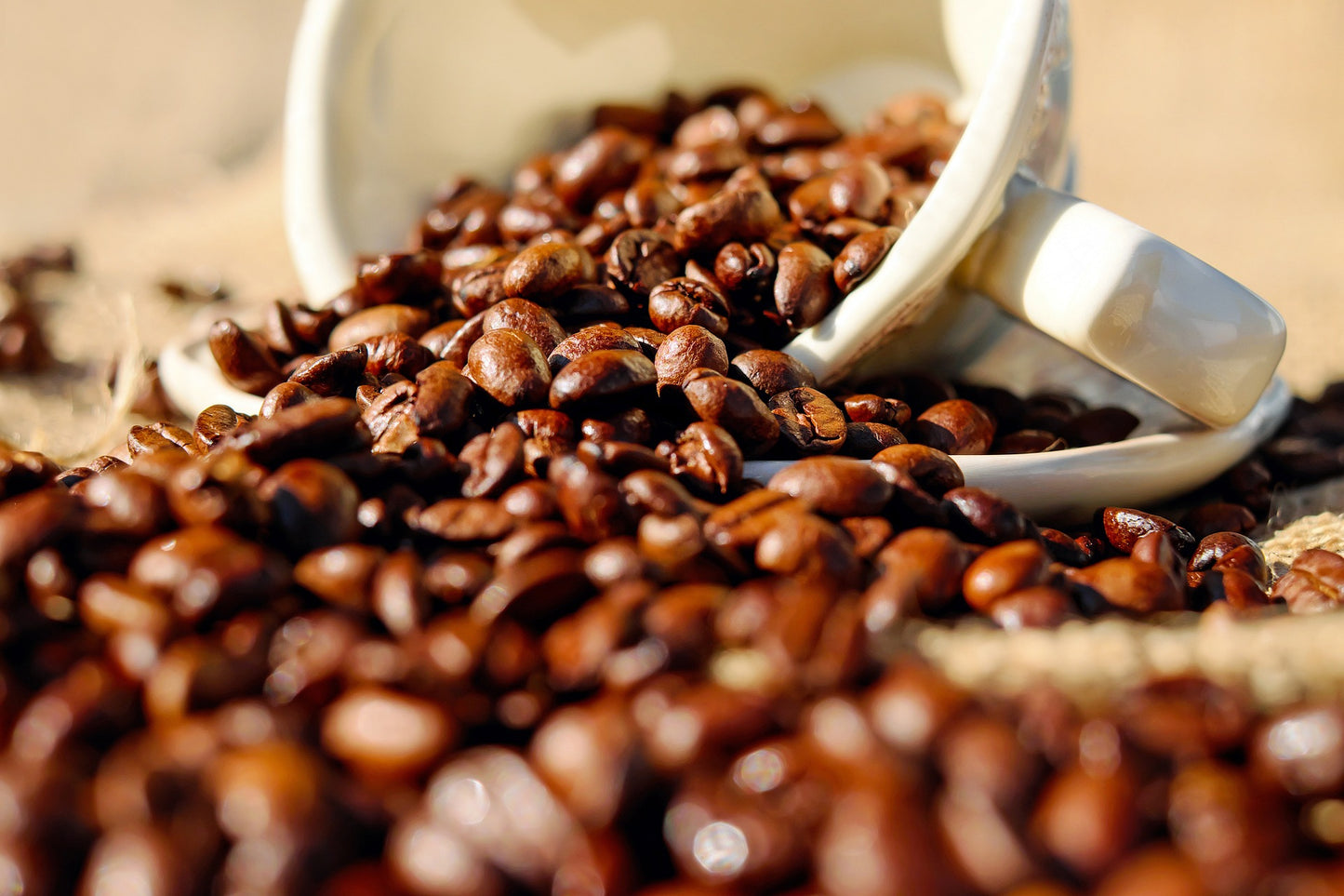Coffee beans spilling out of a cup
